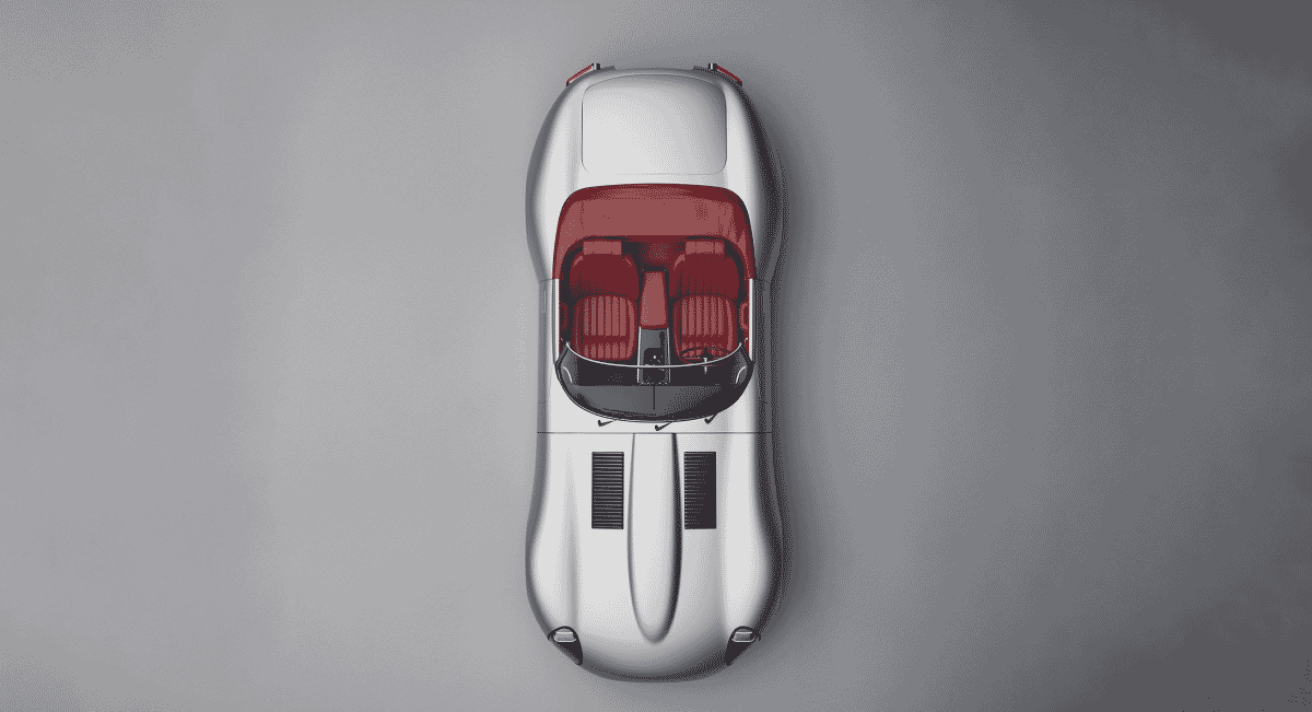 Top-down view of a silver Jaguar E-type convertible with red interior and machined aluminum components.