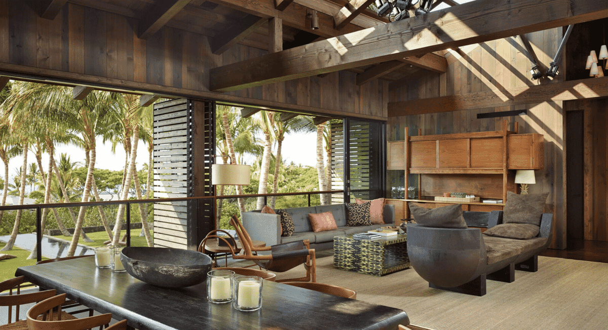 Interior of a rustic Hawaiian residence featuring heavy wood beams and modern seating.