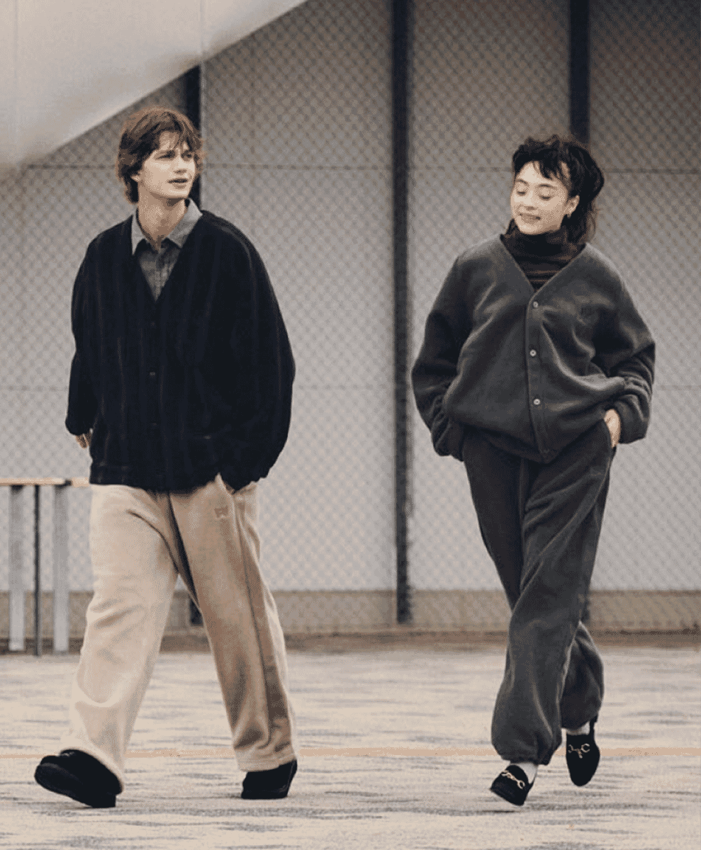 Two models walking in oversized cardigan-style jackets and relaxed trousers.