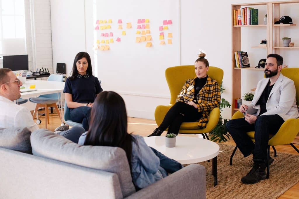 Diverse professional group in a modern office setting where smart-casual footwear and blazers are worn.