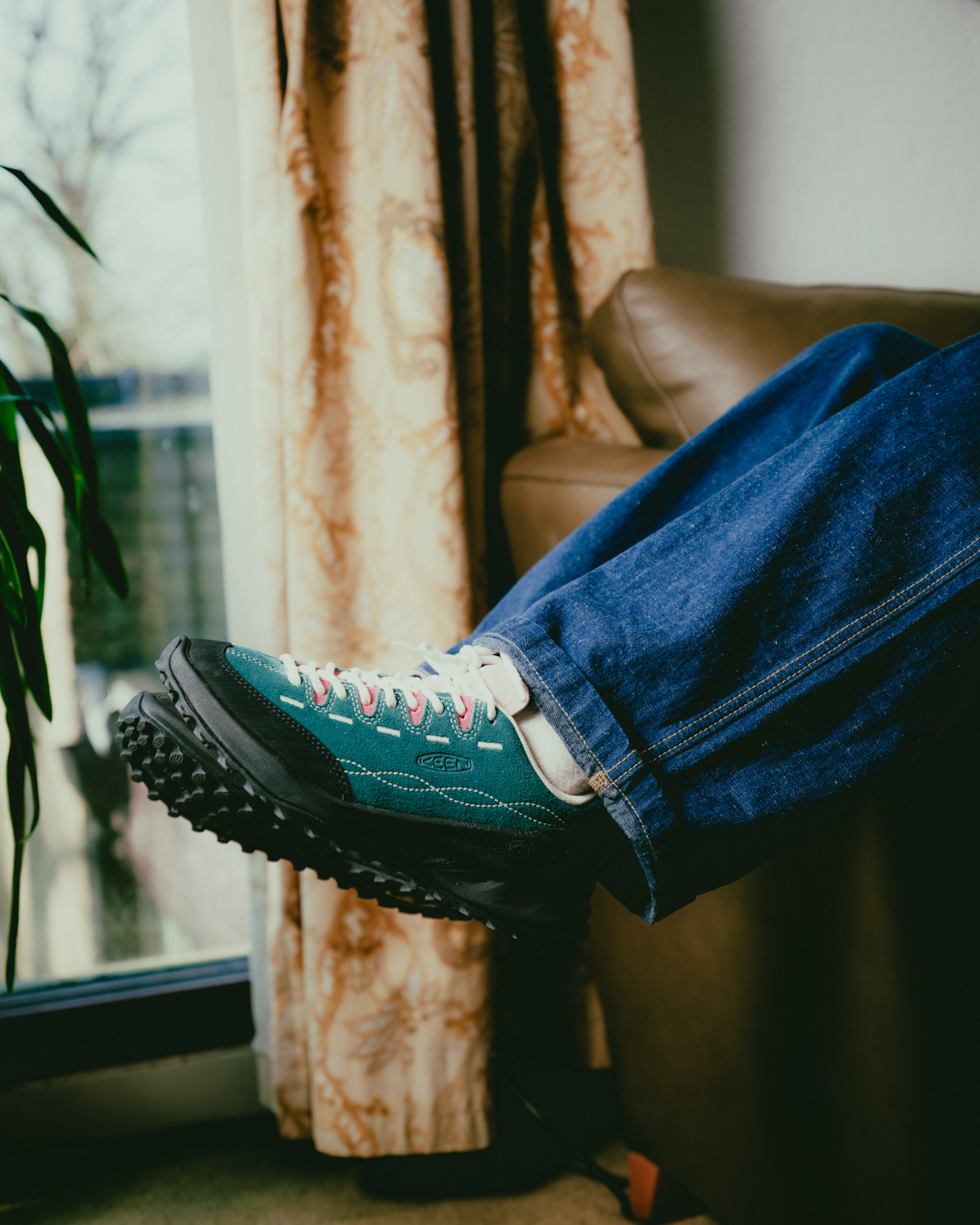 Full-body shot of a model wearing emerald green Jasper Zionic shoes styled with utilitarian cargo trousers.
