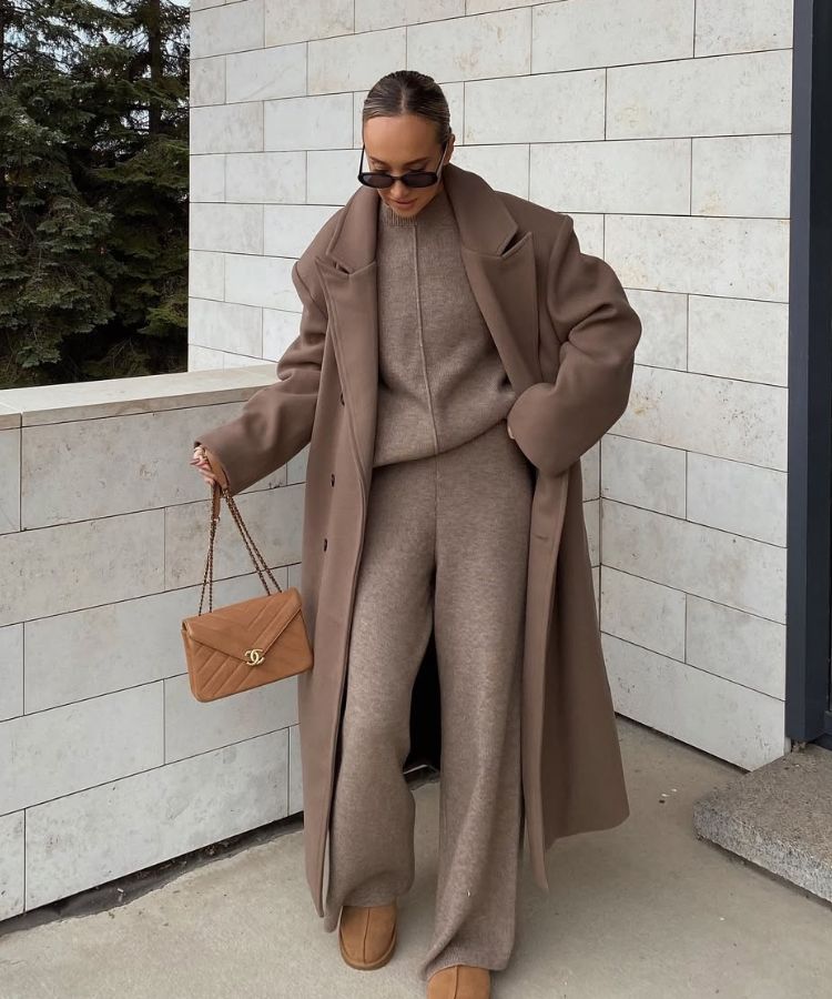 A woman wearing a cozy knit matching set layered under a classic wool coat.