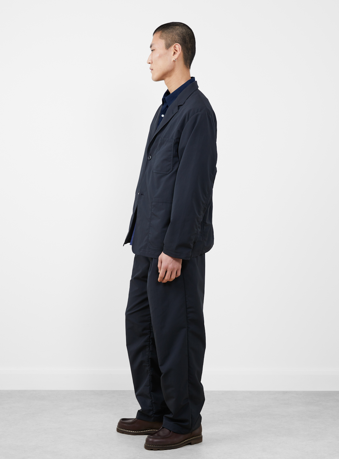 A model layering a COOLMAX tee under a technical vest and light jacket.