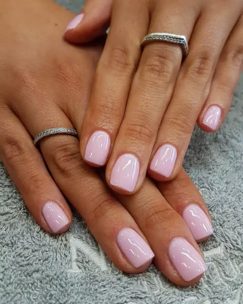 Nude nails featuring a minimalist geometric accent at the cuticle.