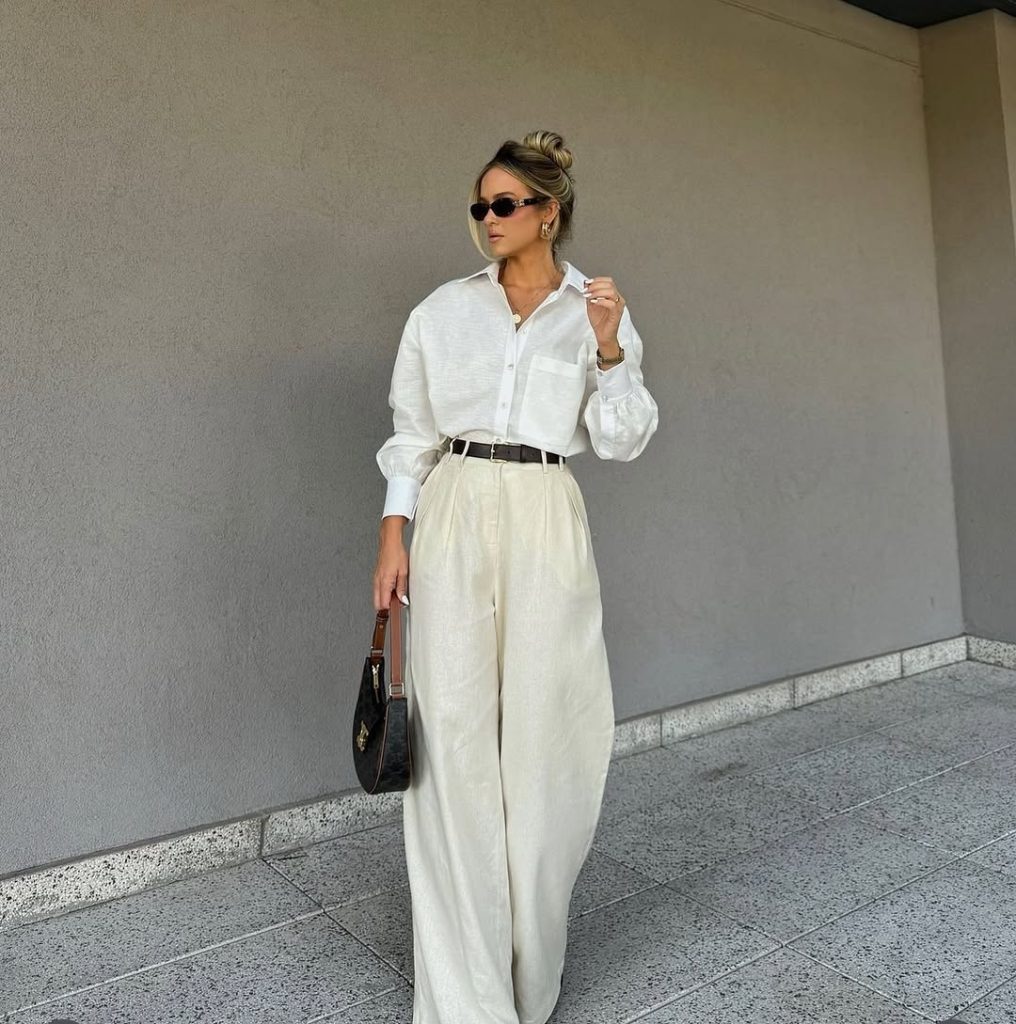 Pointed-toe heels peeking out from under the hem of wide leg trousers.