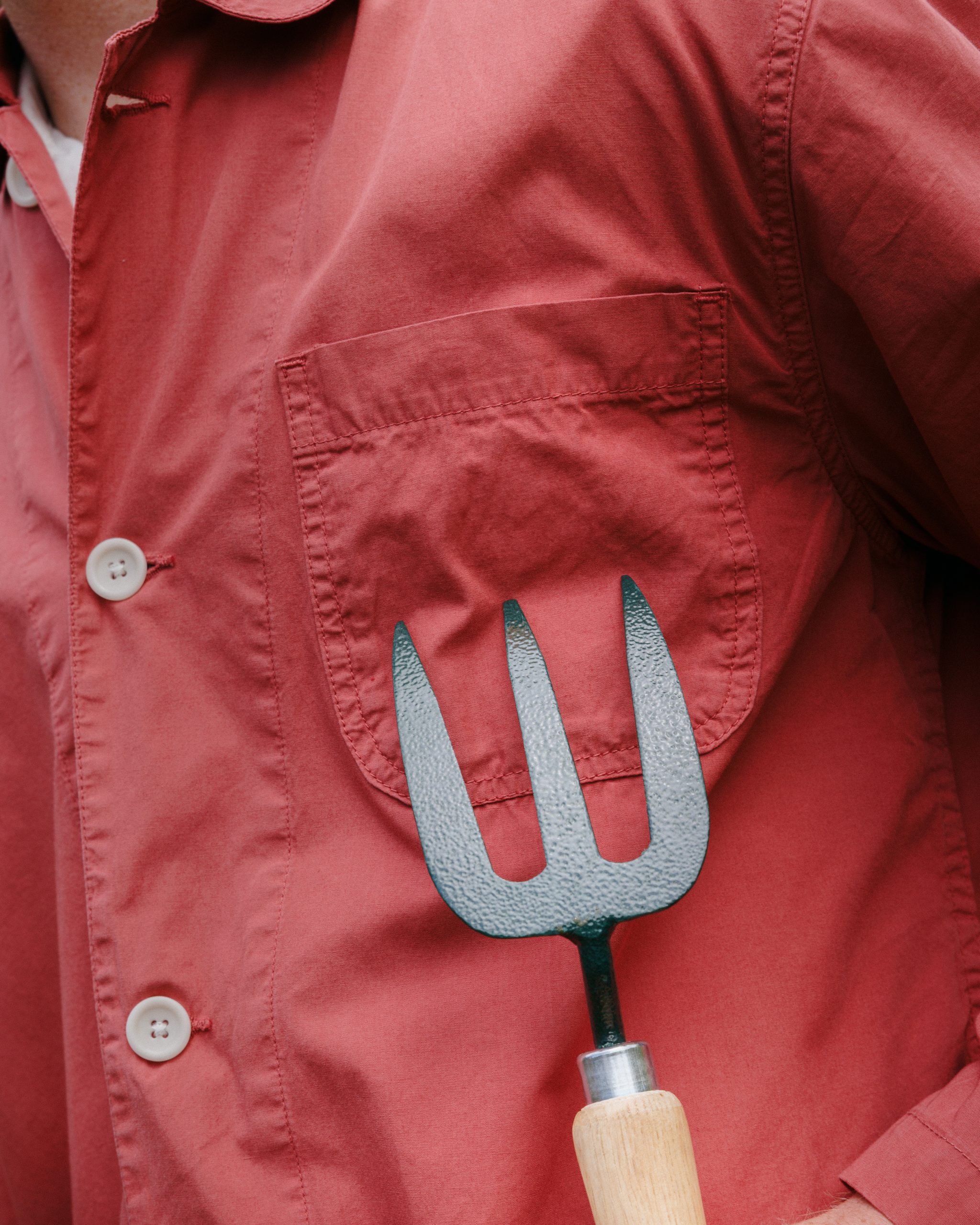 A chef jacket worn open over a high-neck knit sweater with tailored trousers.