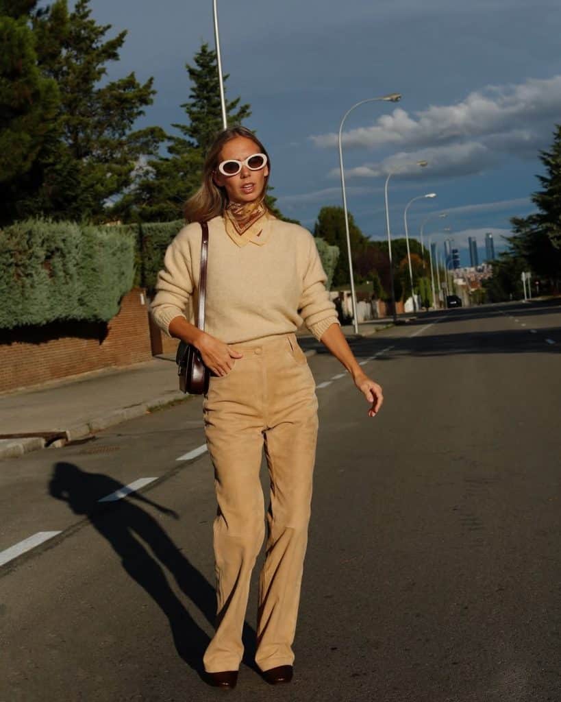 A woman in a beige knit sweater and matching corduroy trousers.