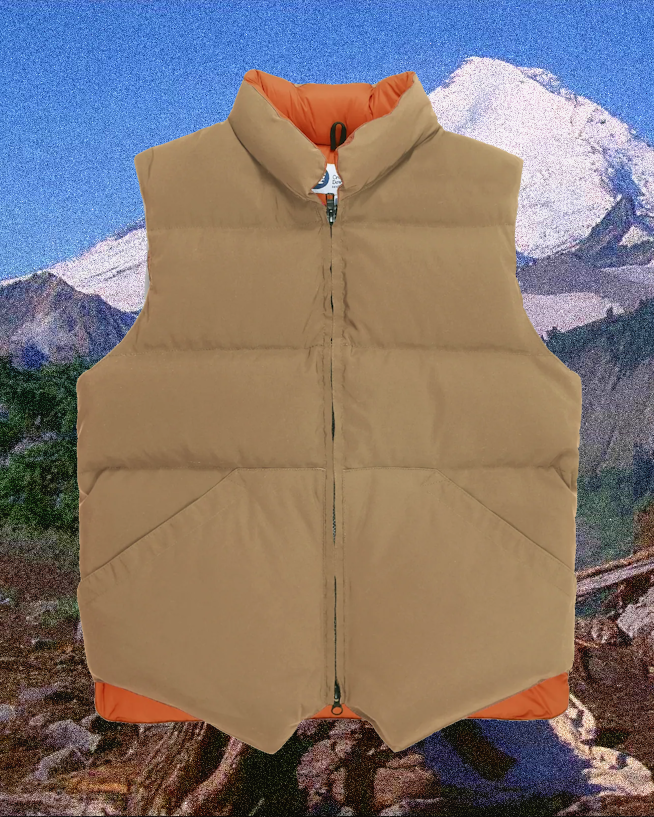 Tan quilted puffer vest with orange interior lining displayed against a mountain range.