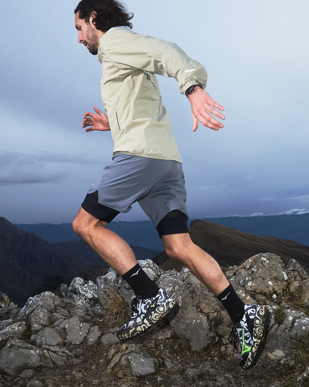 A runner from the back moving away on a trail wearing the Mizuno Neo Accera.