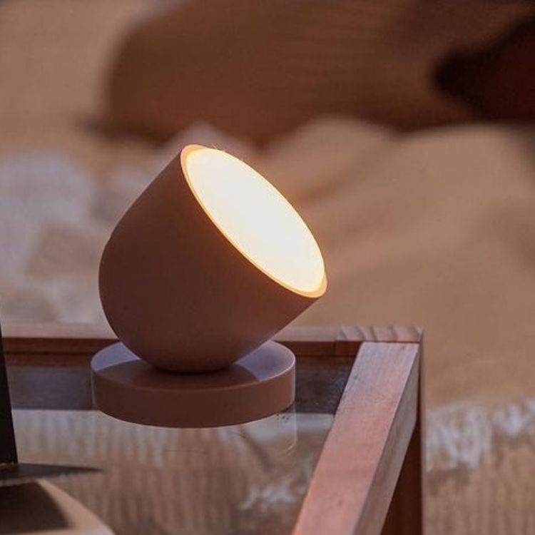 A sleek, circular white light therapy lamp.