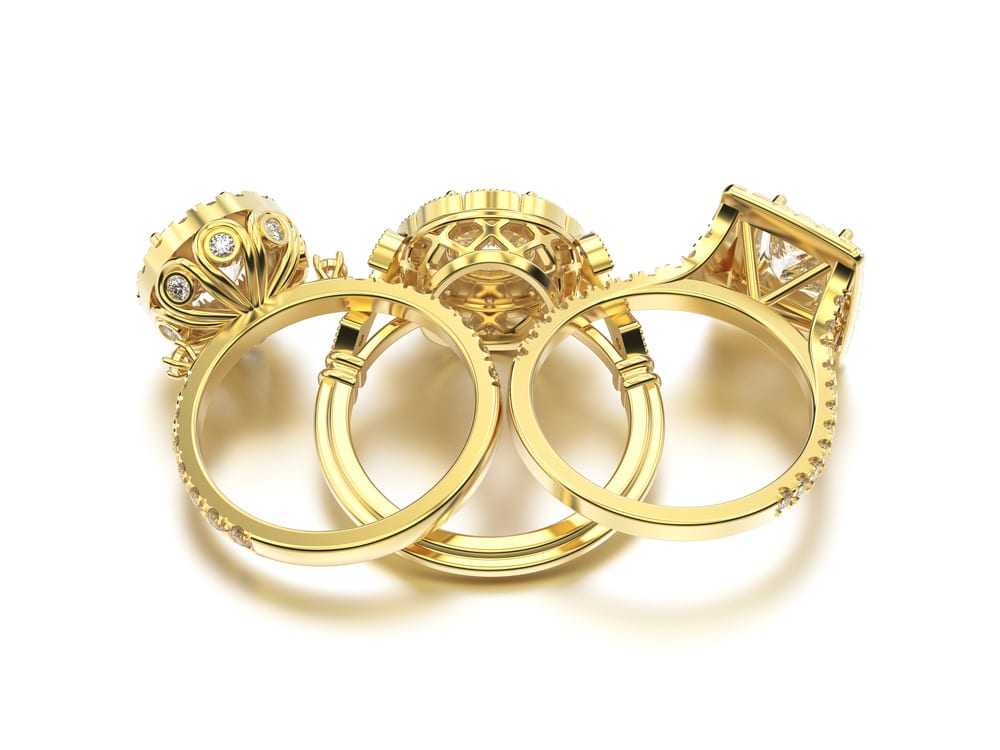 Low-angle lifestyle shot of a bezel-set gold ring styled with a neutral-toned cashmere sweater.