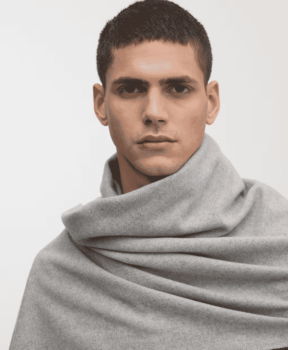 Man wearing a light gray oversized cashmere wool scarf.
