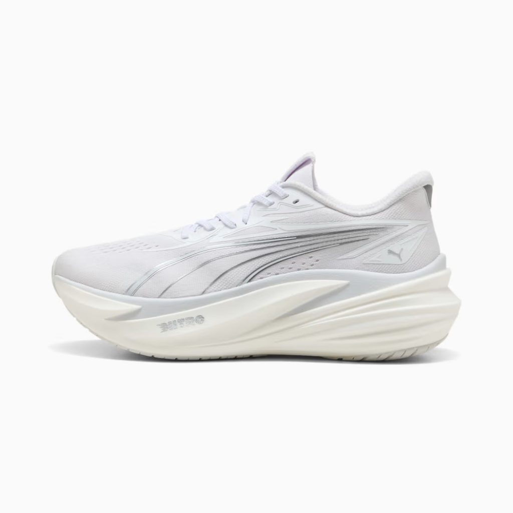 A runner jogging through a park wearing the high-cushion Puma Magnify Nitro 3.