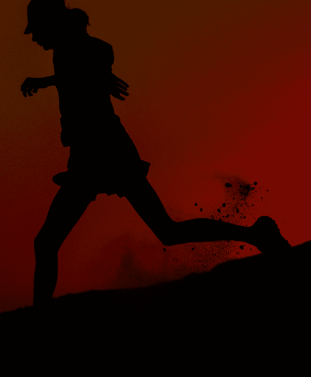 Silhouette of a female runner moving dynamically across rugged terrain against a fiery red-orange gradient.