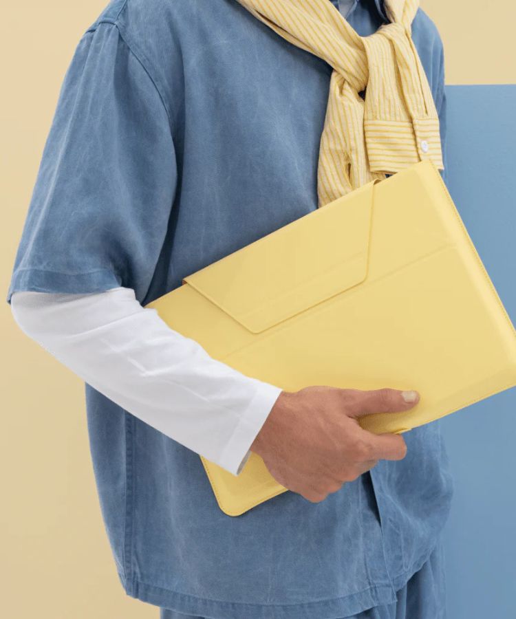 A laptop carry sleeve unfolded to act as an ergonomic stand with a lift.