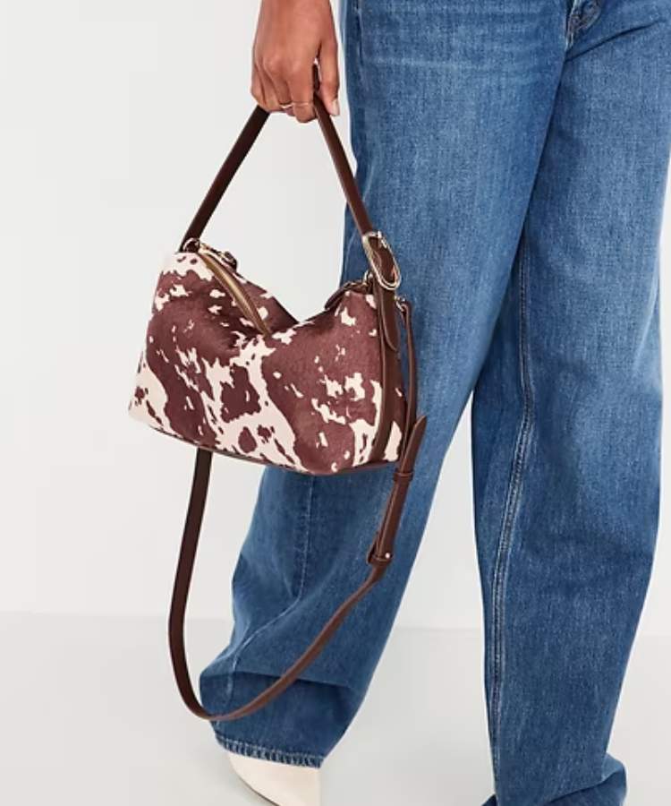 Convertible Carrie Crossbody Bag in a faux calf-hair cow print with a gold metal ring.