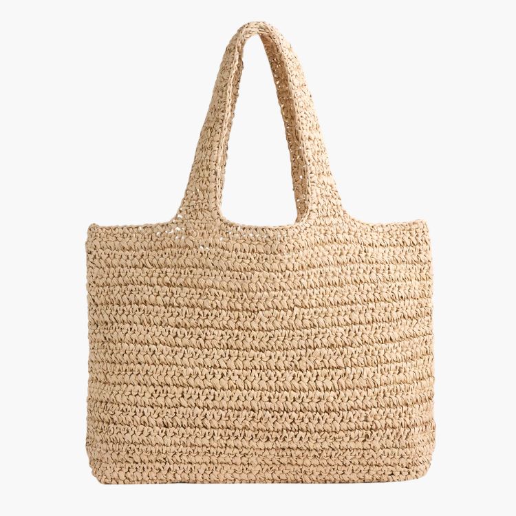 A natural beige hand-woven straw tote bag with a textured pattern.