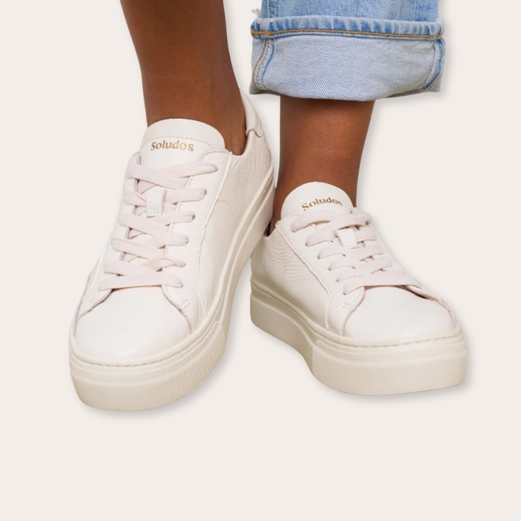 White platform sneakers with elevated soles.