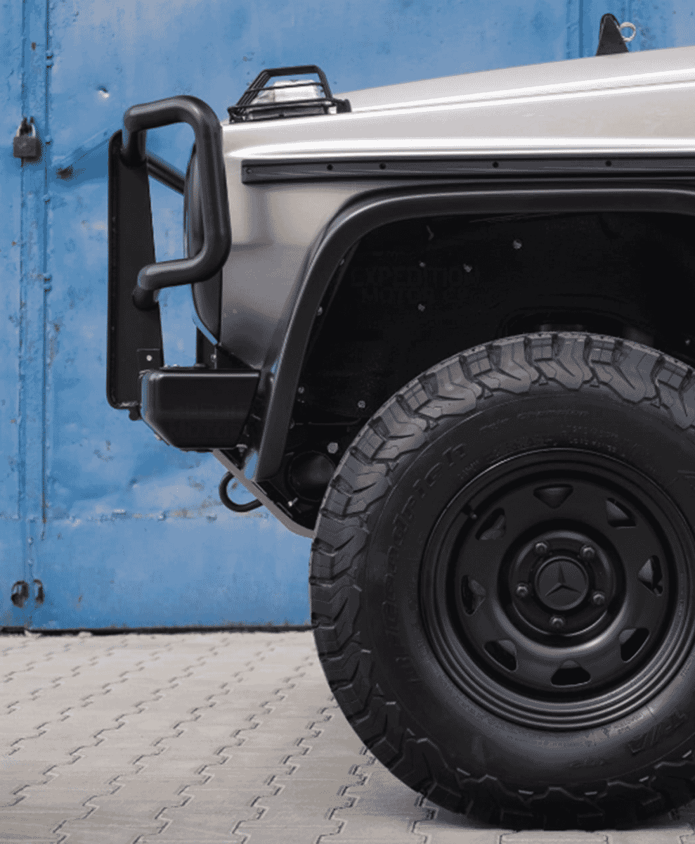 Close-up of a silver Mercedes G-Wagon front bumper guard and off-road tire assembly.