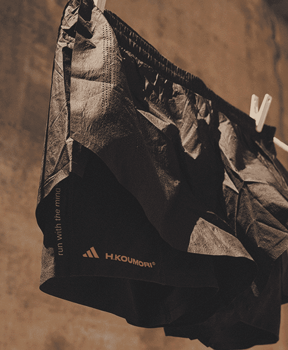 Black technical running shorts hanging in a sepia-toned photo.