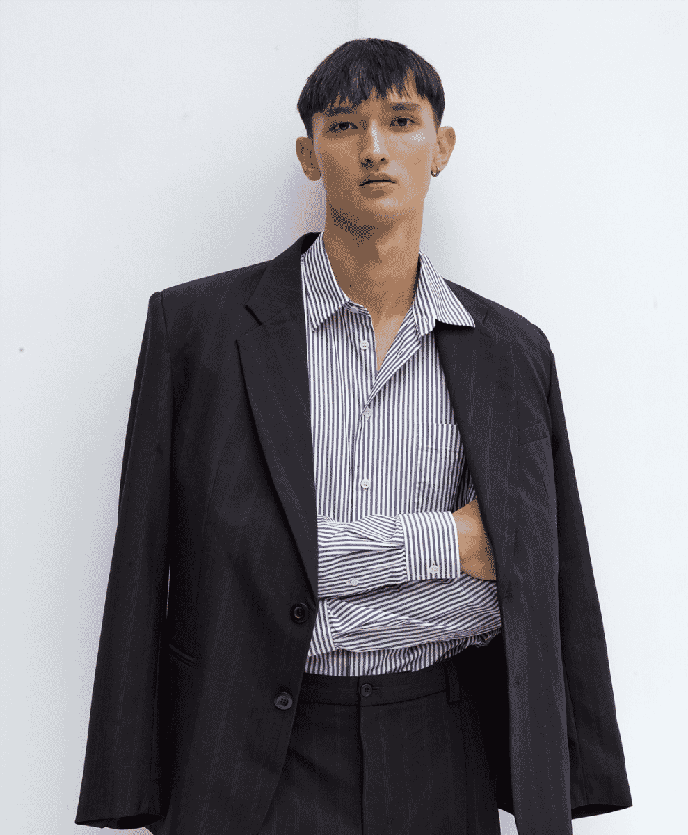 Man wearing a Soulland graphic hoodie with oversized minimalist trousers.