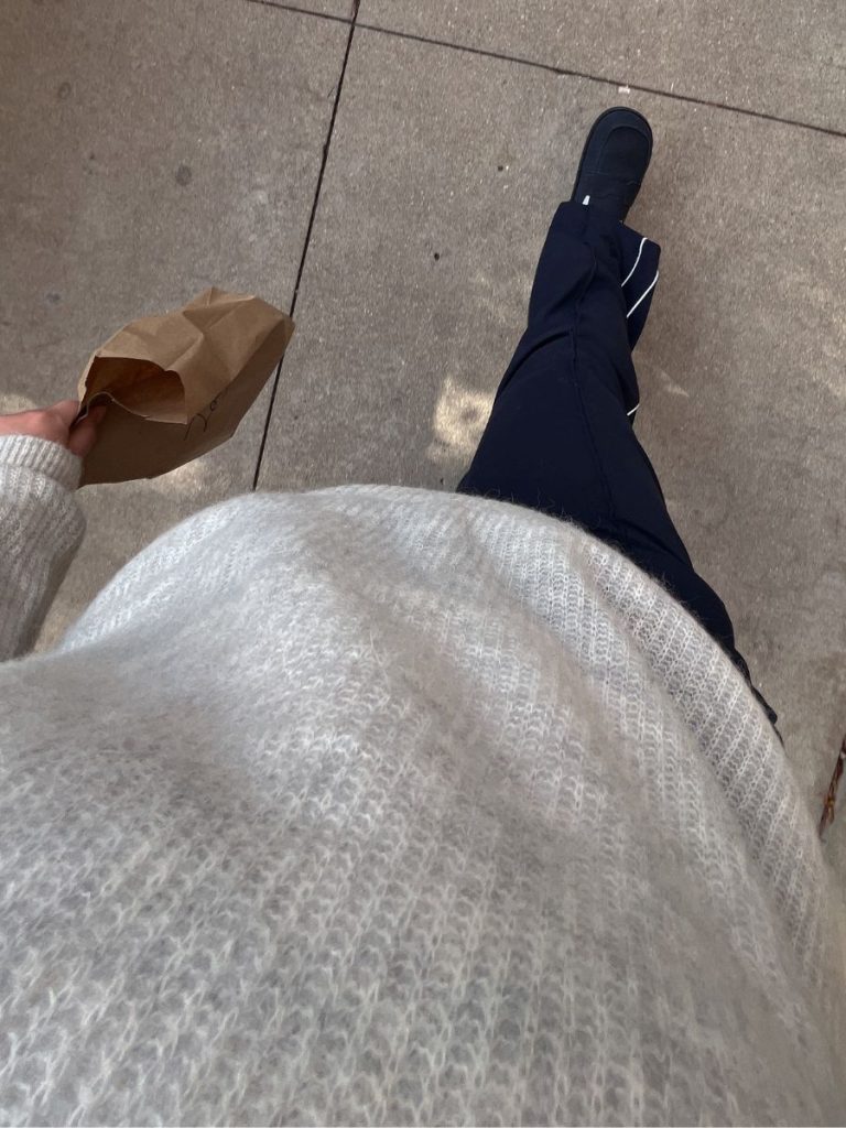 An outfit pairing Athleta Venice track pants with a neutral knit sweater.
