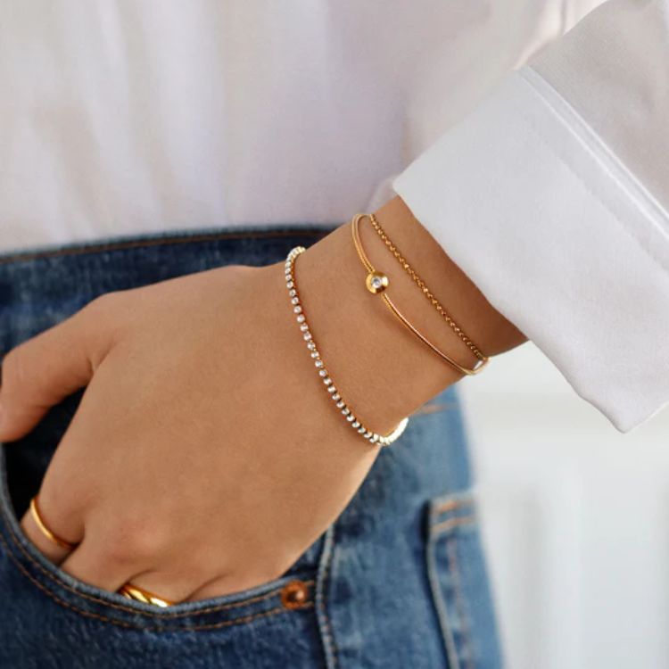 A set of gold-toned waterproof bracelets designed for active wear.