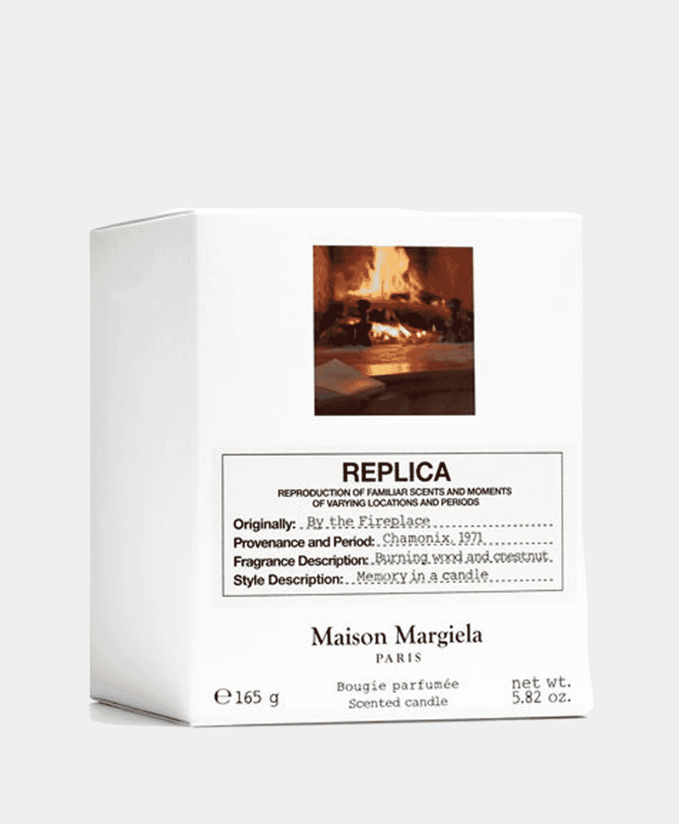 Maison Margiela By the Fireplace candle in a dark, cozy room setting.