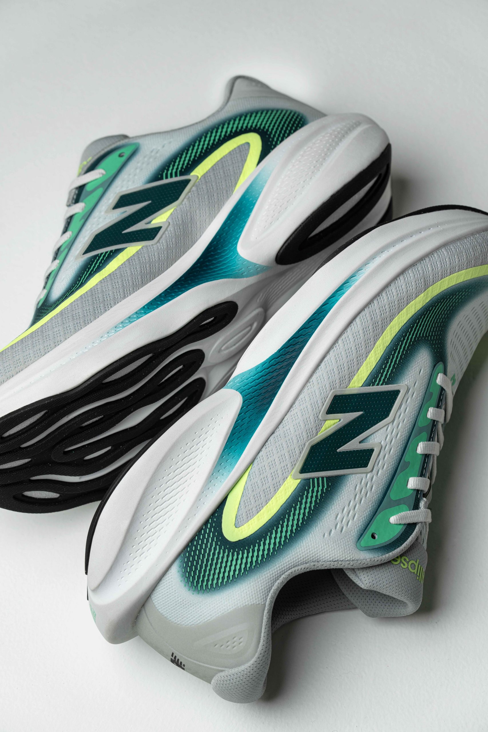 An action shot of the New Balance Ellipse on pavement showing the outsole rubber and rocker shape.