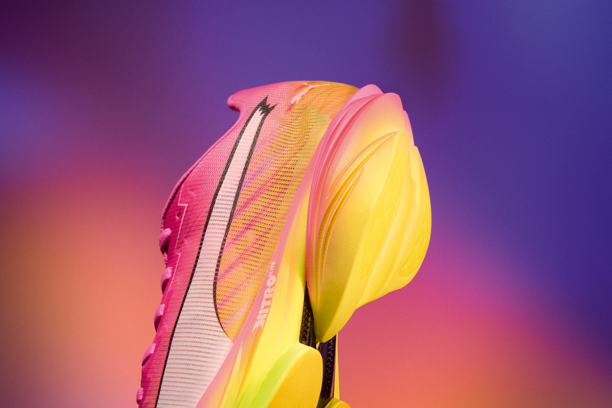 Action shot of a runner in mid-stride wearing the Puma Deviate Nitro 4 on a running track.