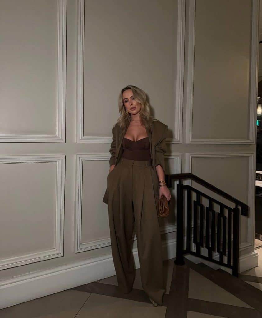 A woman in a monochromatic brown ensemble featuring wide-leg trousers and an oversized blazer.