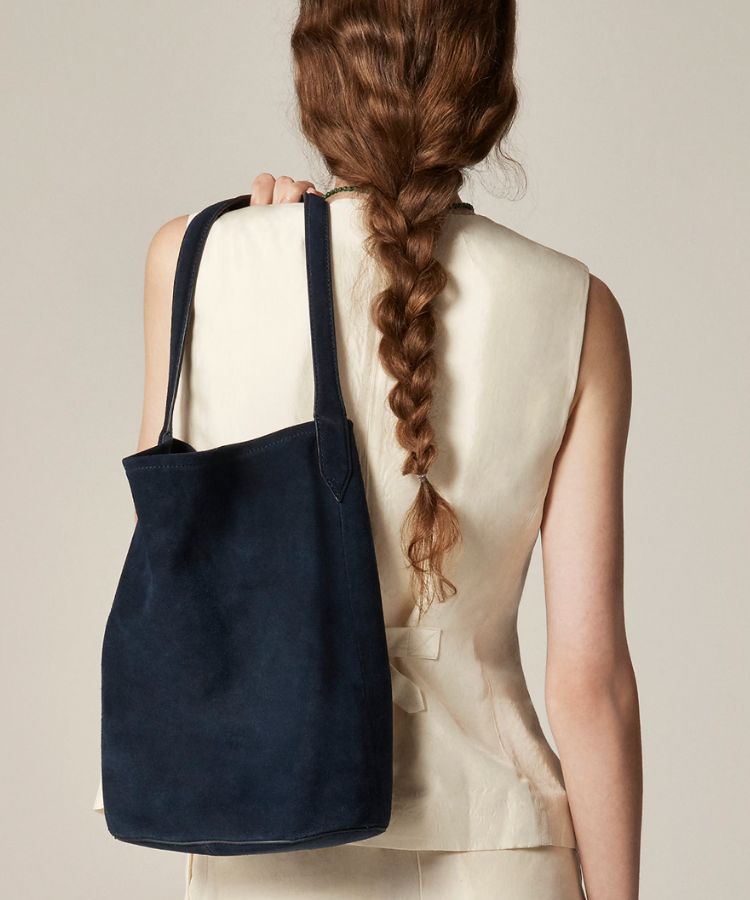 Close-up of the navy blue suede material on the J.Crew bucket bag.